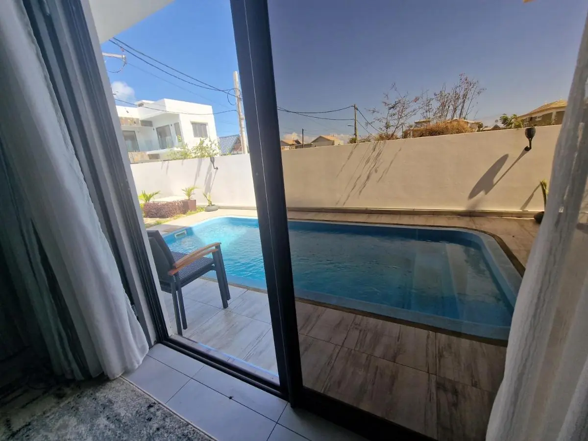 Beautiful view of the private pool from the master bedroom of Luxora Villa in Grand Baie, Mauritius